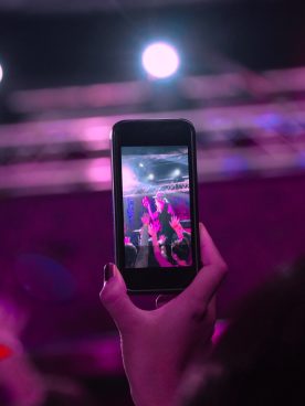 Audience recording video of band on mobile phone in nightclub